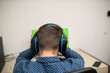 © FarukPhotography - a stressed businessman wears headphones and has an online meeting in his office. a young caucasian businessman wearing a blue shirt in his office