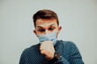 © FarukPhotography - a young caucasian businessman coughs into his hand and wears a mask against the corona virus. corona virus infection