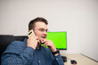 © FarukPhotography - Young caucasian businessman in blue shirt is talking on phone with someone. Businessman is trying to help someone to solve the problem.