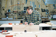© Александр Татаев - A wood craftsman makes a product for a private order, a professional employee makes measurements for working with a wooden product