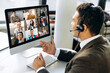 © Kateryna - Online video conference. Successful young adult businessman or manager with headphones discuss with colleagues by video call about financial graphs and strategy and another working moments