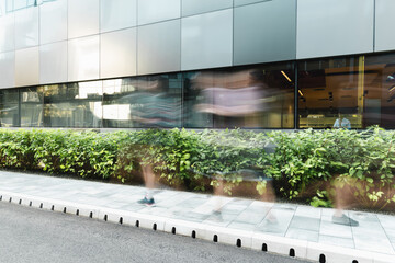 long exposure of people walking on urban street near modern building