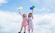 © be free - two sisters hold party balloon. happy childhood. summer vacation. small girls embrace. love and support. concept of sisterhood and friendship. family bonding time. best friends with balloon