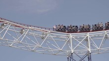 Slow Motion Roller Coaster Riding High Above In UK Theme Park