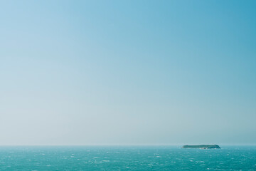 Blue sea and blue sky around Xavier Island seen from Gravata beach in Florianopolis, Santa Catarina, southern Brazil