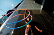© VISTA by Westend61 - Sporty woman exercising with plastic hoops outside modern building