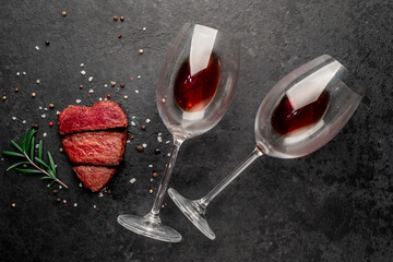 Wall Mural - Dinner for two. Three pieces of meat. three types of roast meat, rare, medium, well done in the shape of a heart, and two glasses with red wine on a stone background 