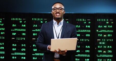 portrait of joyful african american handsome male it technician specialist in glasses standing in se