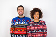 © Roquillo - Young couple wearing Christmas sweater standing against white wall with a happy and cool smile on face. Lucky person.
