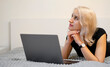 © Anana_go - Pensive girl with laptop. Selection of goods on the site.
