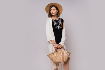 Wall Mural - Wonderful short haired woman in straw hat and summer boho  closes posing on white background in studio.