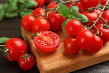 Fresh cherry tomatoes and basil on wooden table, closeup