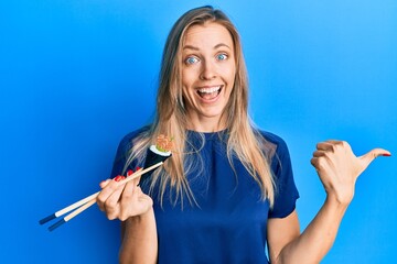 Poster - Beautiful caucasian woman eating temaki sushi using chopsticks pointing thumb up to the side smiling happy with open mouth