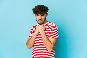 Wall Mural - Young arab man on blue background scared and afraid.