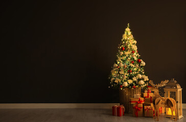 Beautiful Christmas tree, festive decor and gift boxes near black wall indoors, space for text