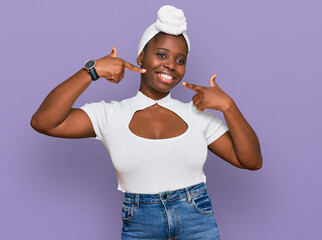 Sticker - Young african woman with turban wearing hair turban over isolated background smiling cheerful showing and pointing with fingers teeth and mouth. dental health concept.