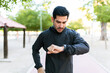 © AntonioDiaz - Athletic man checking his smartwatch outdoors