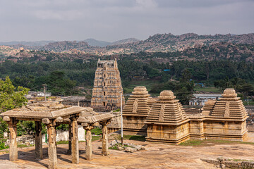 Hampi, Karnataka, India - November 4, 2013: Virupaksha Temple complex. Aarial view on brown-yellow stone Shiva Vimanam and other buldings with green landscape in back.