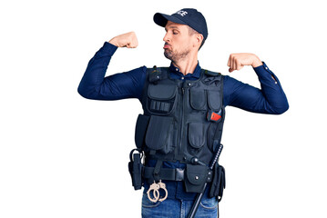 Canvas Print - Young handsome man wearing police uniform showing arms muscles smiling proud. fitness concept.