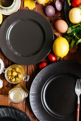 Wall Mural - black plates on a wooden background with vegetables and fruits l