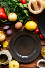 Wall Mural - black plates on a wooden background with vegetables and fruits l