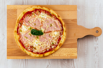 Sticker - Italian pizza on a wooden Board and light background