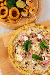 Italian pizza and beer snacks on a wooden Board and light backgr