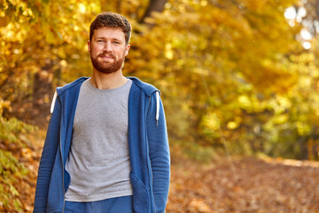 bearded man walking in the autumn yellow park, looking at camera. Lonely, dreamer, in search of himself, progress, style