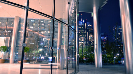 Pattern of office buildings windows illuminated at night. Lighting with Glass architecture facade design with reflection in urban city.