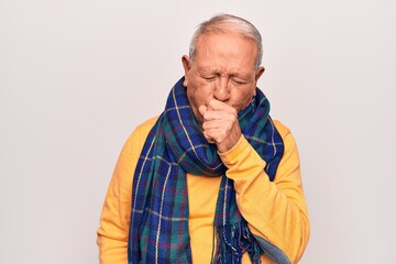 Poster - Senior handsome grey-haired man wearing casual scarf over isolated white background feeling unwell and coughing as symptom for cold or bronchitis. Health care concept.