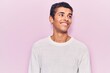 Young african amercian man wearing casual clothes looking to side, relax profile pose with natural face and confident smile.