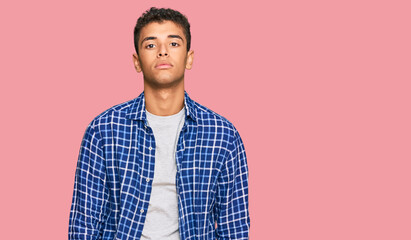 Poster - Young handsome african american man wearing casual clothes relaxed with serious expression on face. simple and natural looking at the camera.