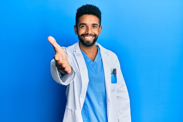 Canvas Print - Handsome hispanic man with beard wearing doctor uniform smiling friendly offering handshake as greeting and welcoming. successful business.