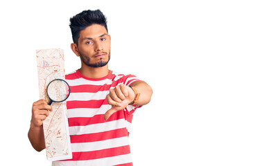 Sticker - Handsome latin american young man looking at city map with magnifying glass with angry face, negative sign showing dislike with thumbs down, rejection concept