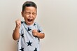 © Krakenimages.com - Adorable latin toddler wearing casual clothes celebrating surprised and amazed for success with arms raised and eyes closed