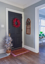 Black Door With Red Berry Wreath In Charming Older Home
