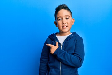 Canvas Print - Little boy hispanic kid wearing casual sporty jacket smiling cheerful pointing with hand and finger up to the side