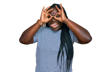 Sticker - Young black woman with braids wearing casual clothes doing ok gesture like binoculars sticking tongue out, eyes looking through fingers. crazy expression.