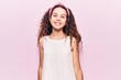 © Krakenimages.com - Beautiful kid girl with curly hair wearing casual clothes looking positive and happy standing and smiling with a confident smile showing teeth