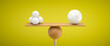 wooden scale balancing one big ball and four small ones on colorful background