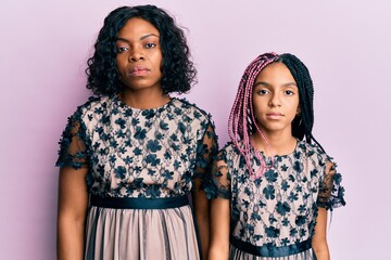 Sticker - Beautiful african american mother and daughter wearing sexy party dress with serious expression on face. simple and natural looking at the camera.