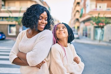 Poster - Beautiful african american mother and daughter smiling happy and hugging. Standing with smile on face standing at the city.