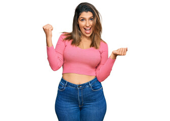 Canvas Print - Beautiful brunette woman wearing casual clothes screaming proud, celebrating victory and success very excited with raised arms