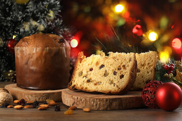 Delicious slice of Panettone with candied fruit on the table on a blurred background.