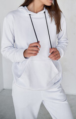 Wall Mural - girl wears white sportswear. copy space clothes without a logo. woman wears white hoodie and white pants