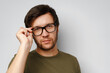 © fotofabrika - Portrait of a serious pensive young man against grey background