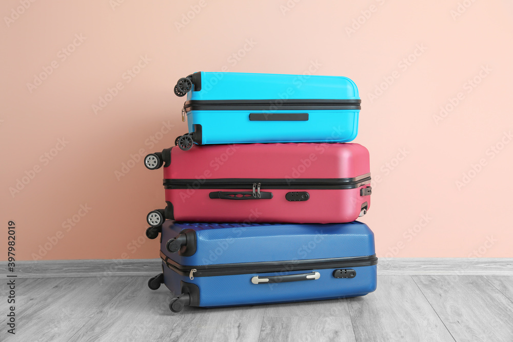 Packed suitcases near color wall