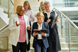 © Roman - team of diverse women colleagues on stairs talking, discussing business ideas and strategies. business people, cooperation concept