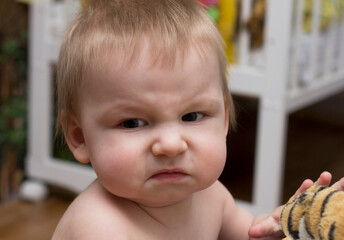 Portrait of a baby with disgust facial expression