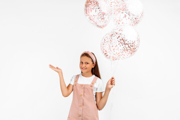 happy little girl, with many balloons in hand, having fun and celebrating on an isolated white background